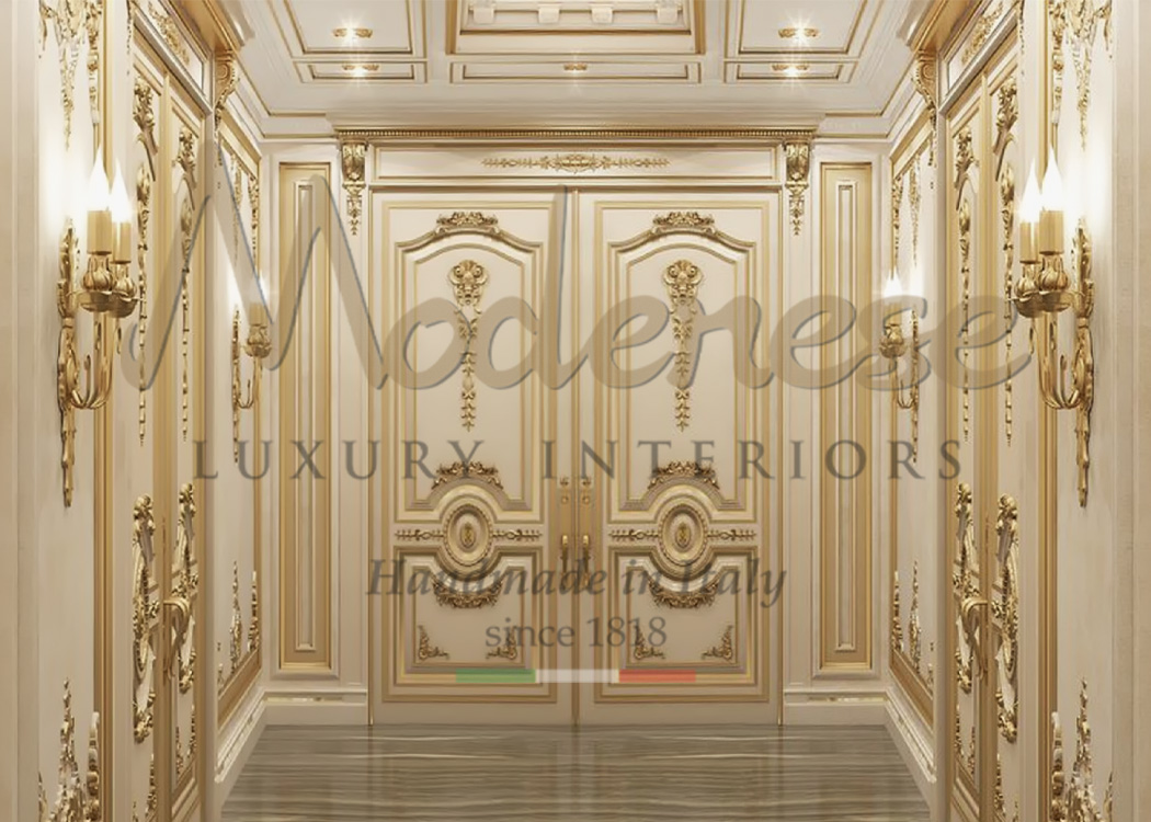 Elegant white door with gold leaf details on a corridor with matching wall panels by Modenese