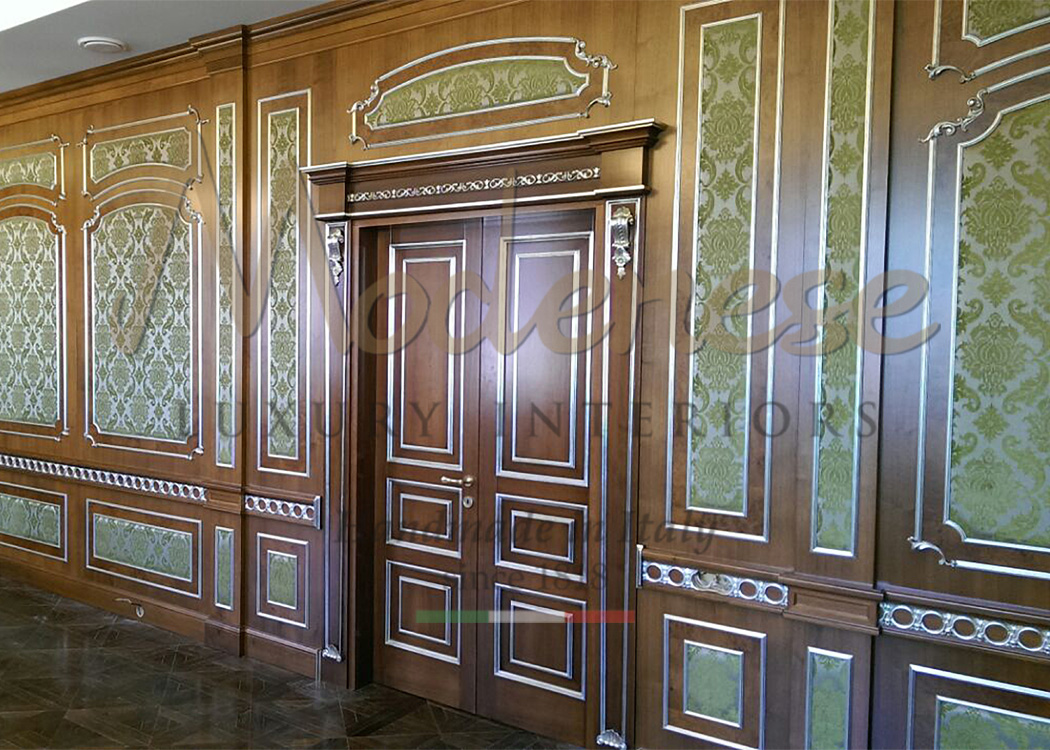 Classic walnut doors with silver leaf decorations and green wallpaper for Modenese interior design projects