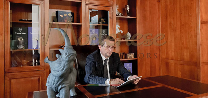 Modenese Gastone son Renzo working in his office with rhino statue beside him